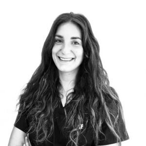Dr Valentine Veniat Portrait en noir et blanc du Dr Valentine Veniat, dentiste à Lyon, souriante en tenue professionnelle.